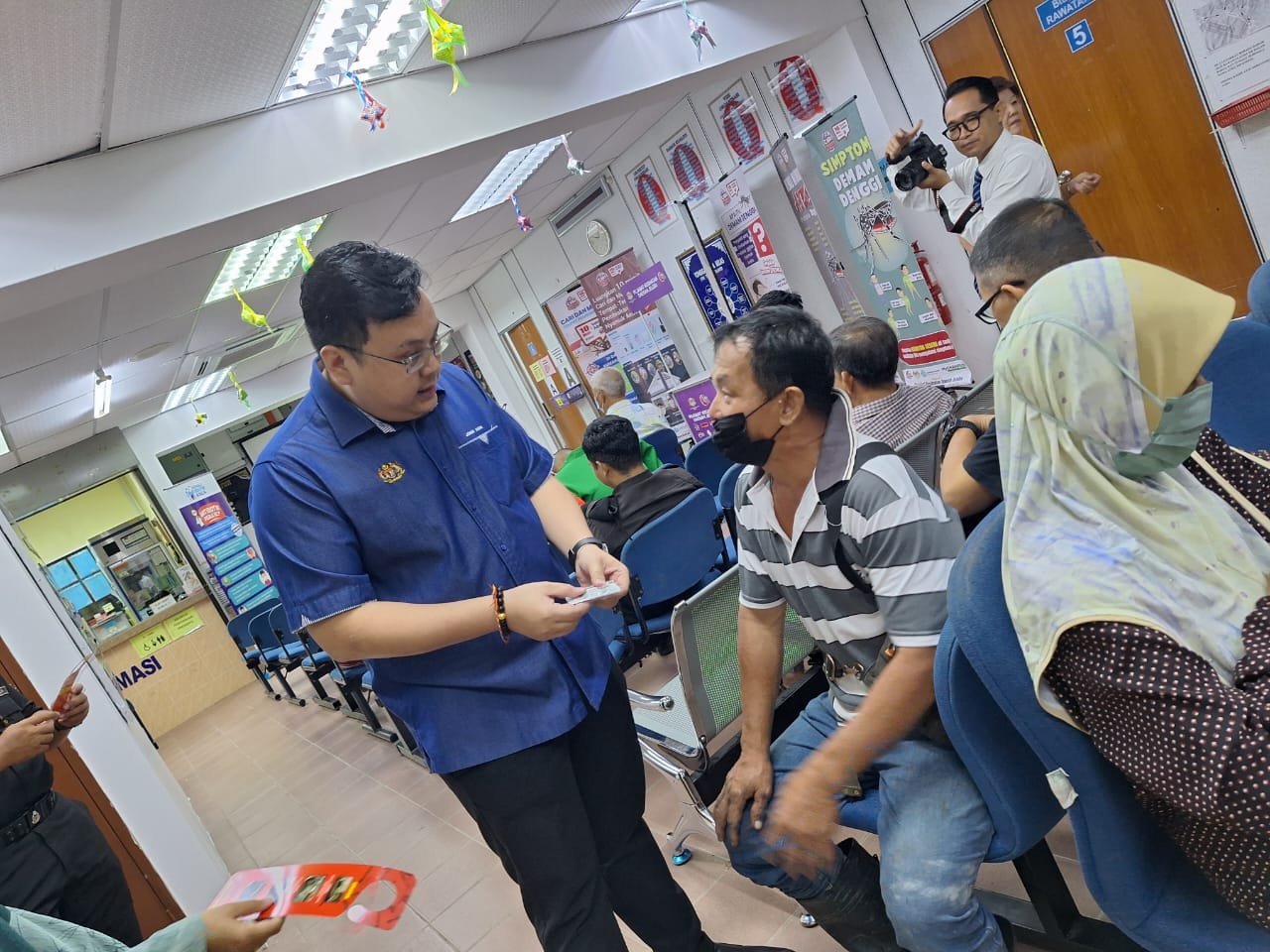 萧康骏协助当局派发灭蚊药给与到来的村民，让大家可以一起协助防止骨痛热症的发生。