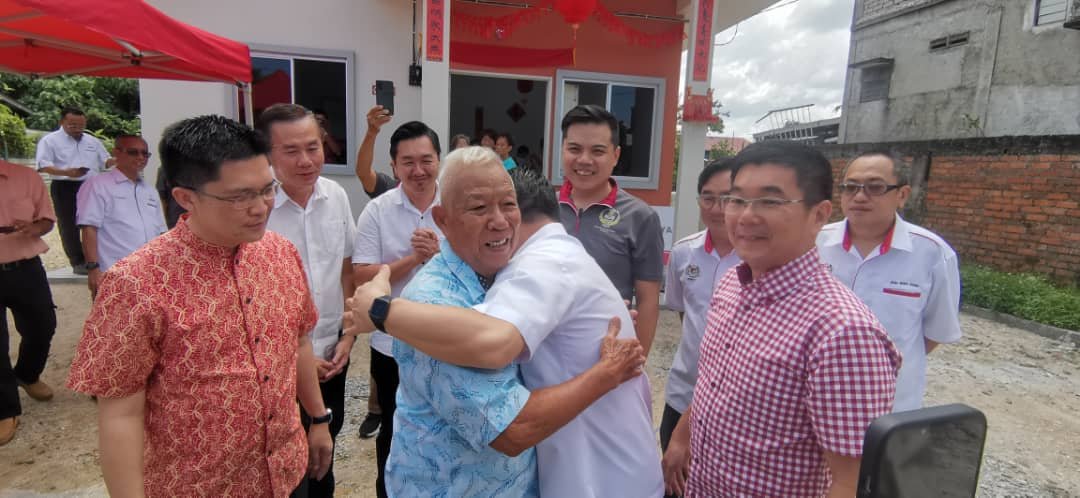 苏坤鸿（左2起）拥抱倪可敏，感激后者协助重建村屋。