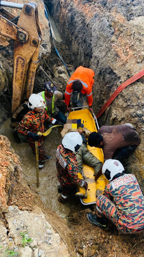 消拯人员合力将遭到塌陷土壤活埋的59岁焊工遗体移出深坑。