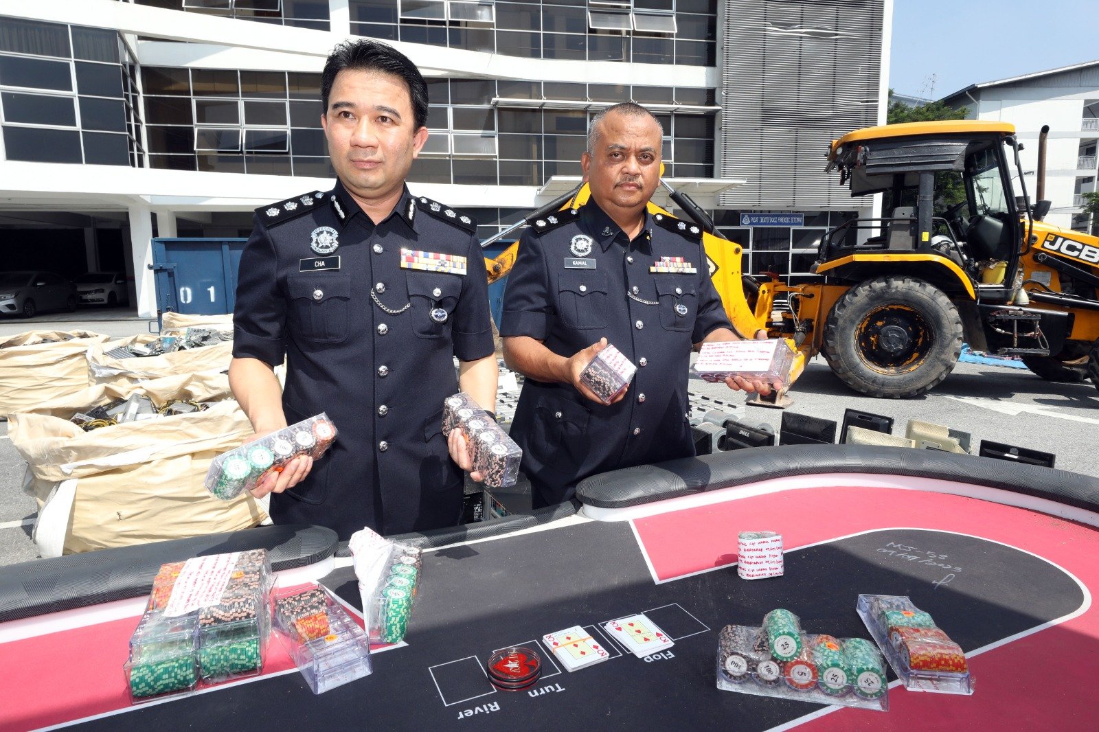谢鸿方（左）和卡玛（右）向媒体展示在取缔行动中被警方充公的赌桌。
