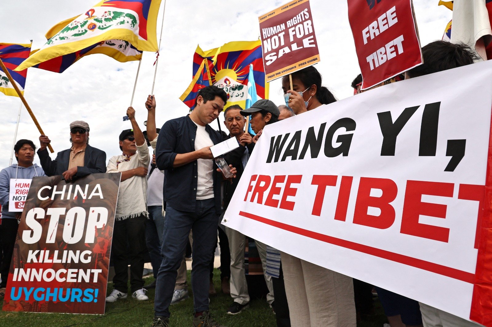 在堪培拉的国会大厦外，抗议中共政权受害者联盟组织集会，澳洲藏人社群成员举著旗帜和标语牌。（图取自法新社）