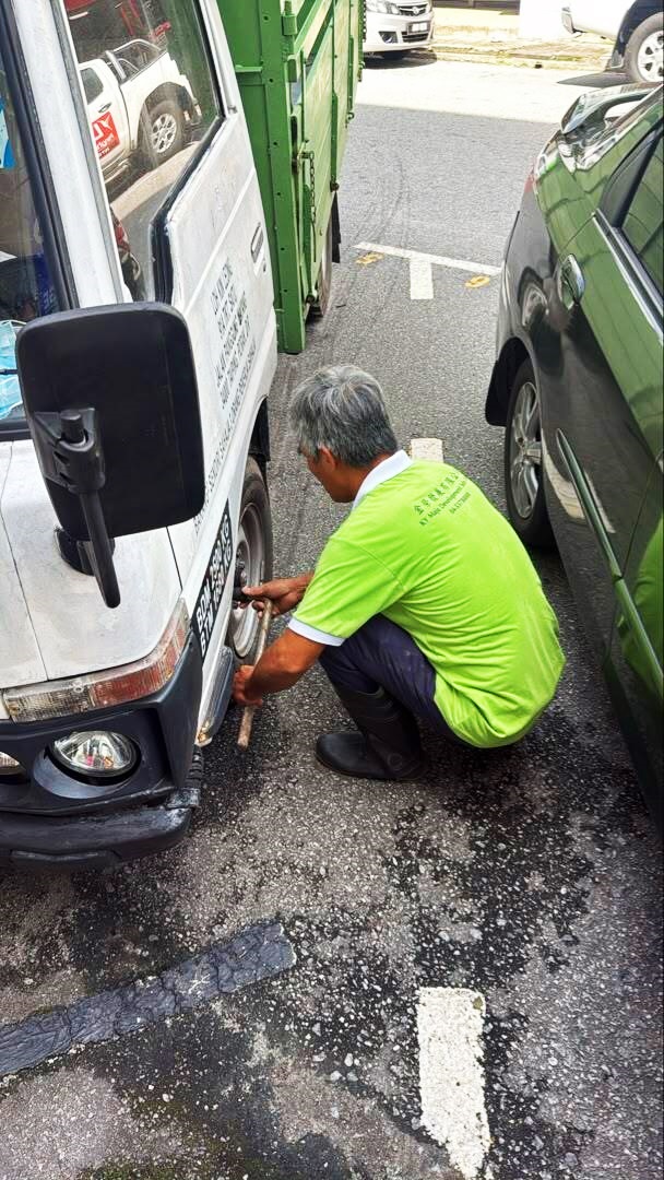 罗里前轮遭人放气后完全泄气，司机只能求助轮胎店，等待技工到场充气。（社媒图）