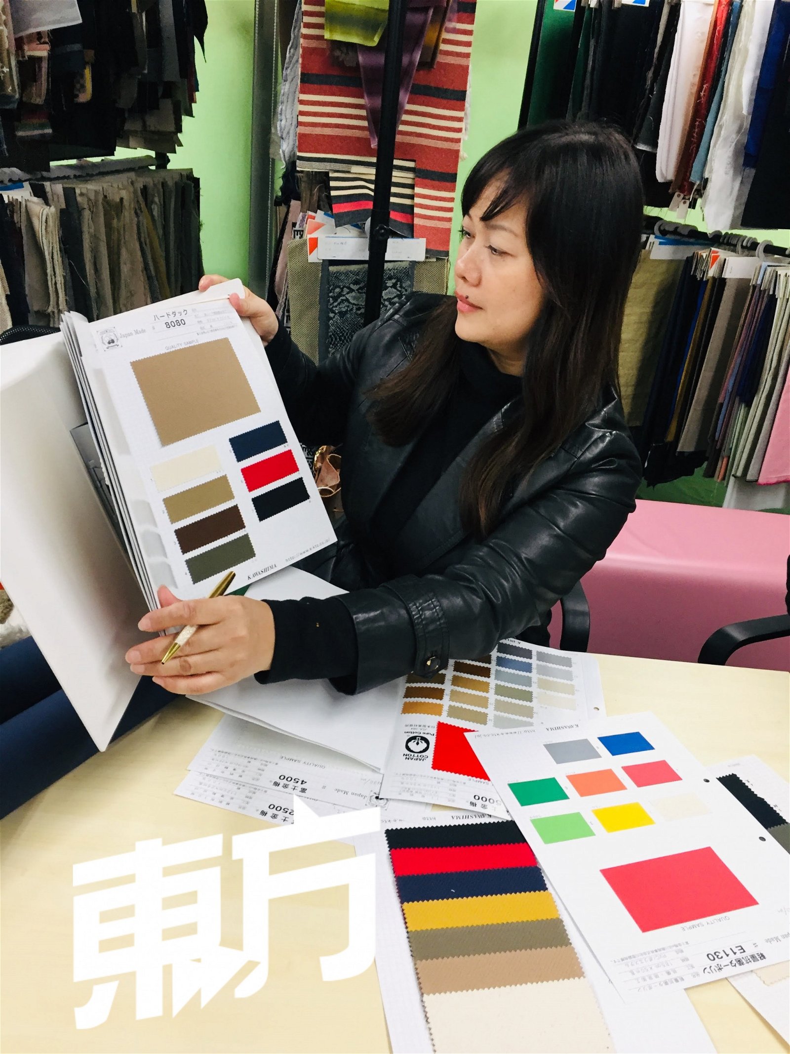Christy Studio的包包大多采用日本防水帆布制作，因此和翠燕每年都会亲自飞往日本挑选布料。图为她在日本布料厂挑选布料的画面。