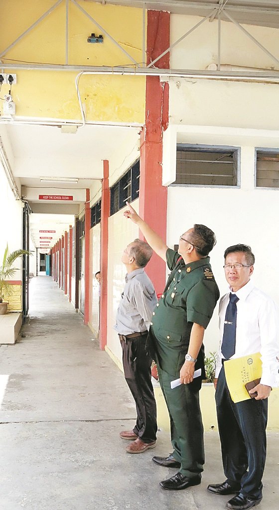 罗永忠督学（中）在陈细峇（左）及林洸安的陪同下，巡视学校的保安措施。