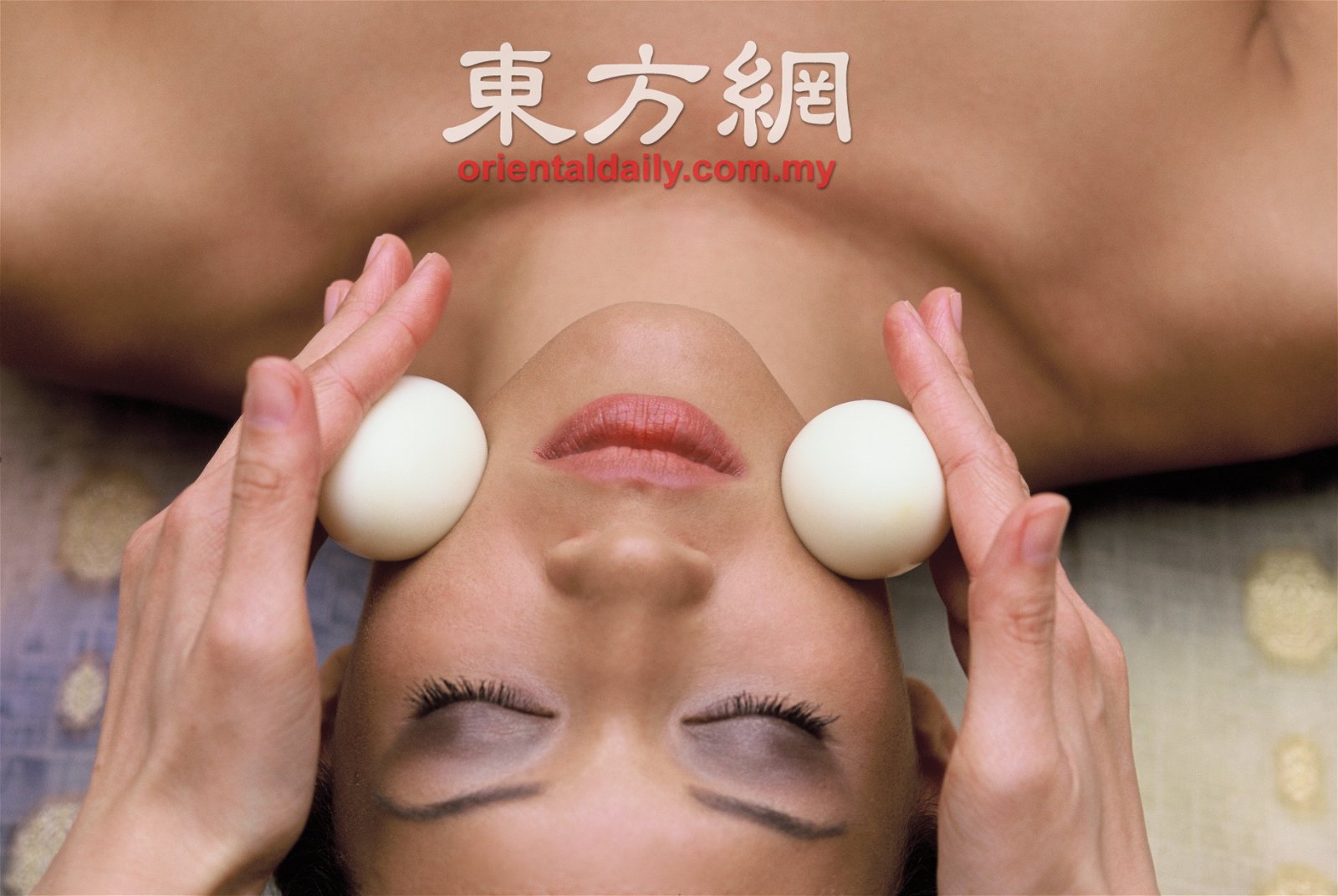 理疗师利用温热的鸡蛋，在脸蛋上滚动，让肌肤更加紧致有光泽。