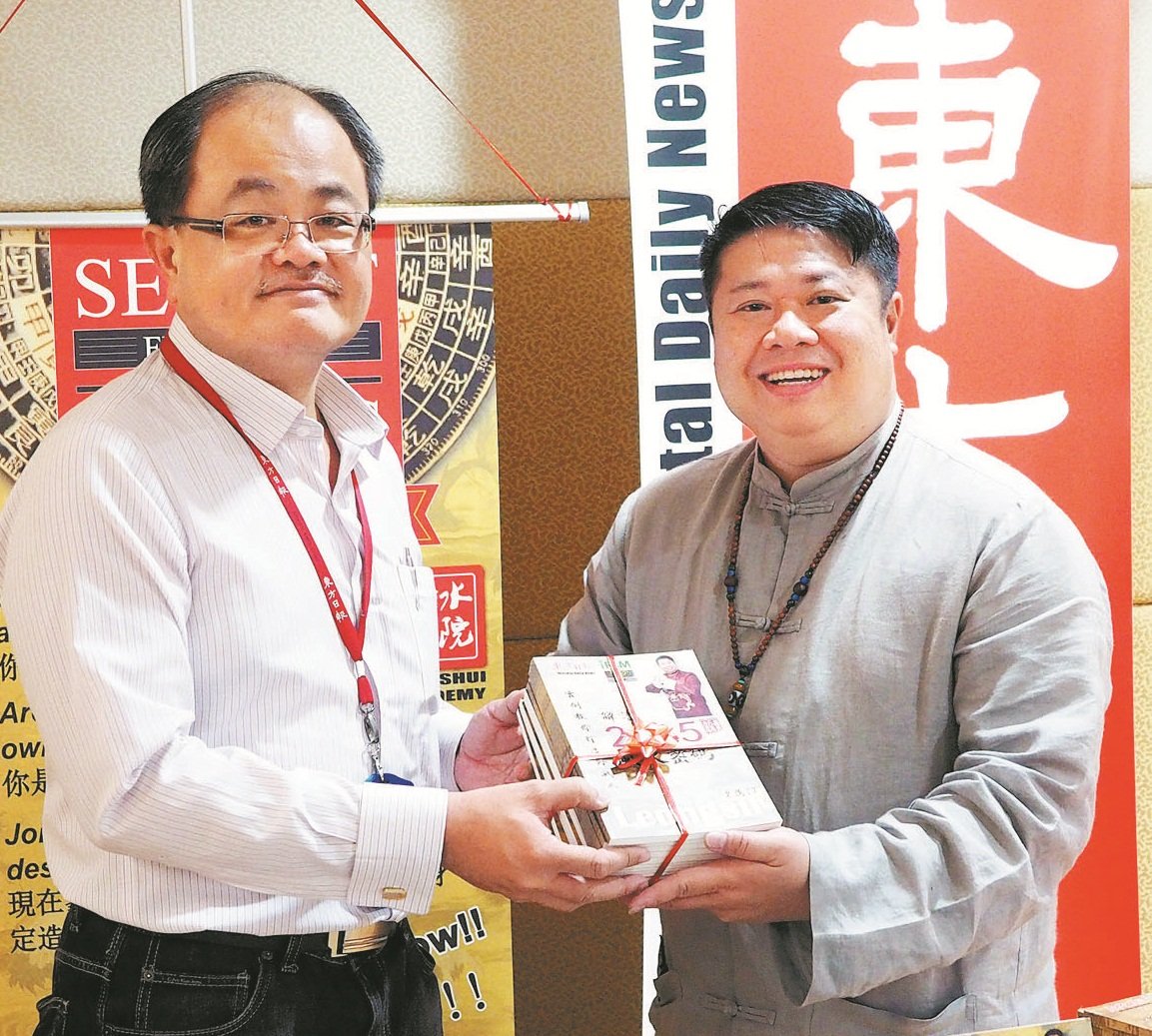 梁庸陞（右）赠送新书《解读2015风水密码》给陈利良。