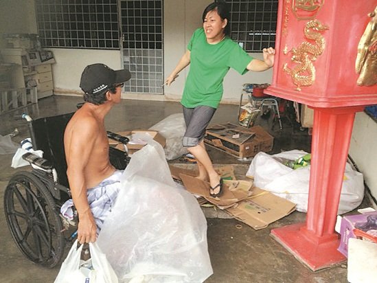 朱新豪（左）回到家后，与妻子张丽珠一起整理纸皮及铝罐等回收物。
