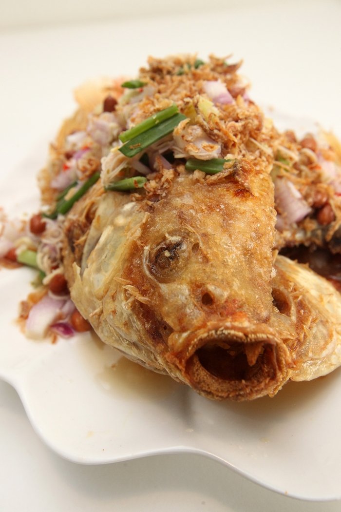 【Pla Sa Mhun Prai】油炸至酥脆的非洲鱼，在铺上满满的香茅粒、葱头粒和花生，吃起来香气逼人，加上咸甜辣的味道交织出美妙滋味。售价：35令吉