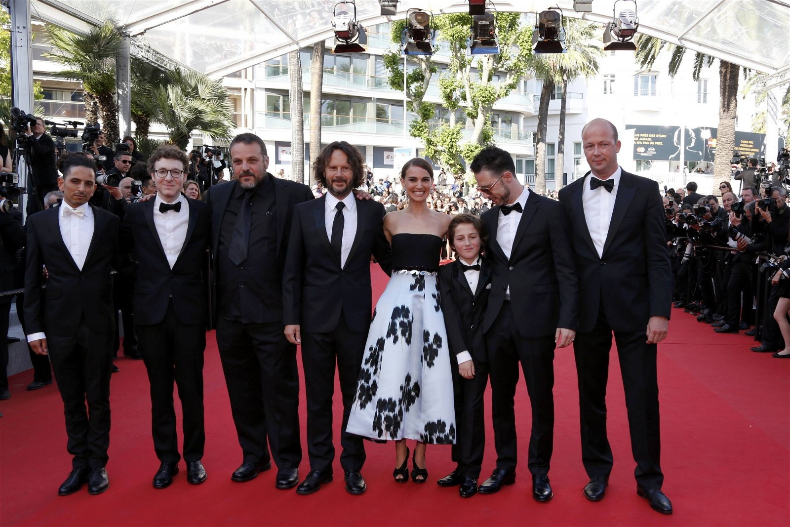 电影《爱与黑暗的故事》（A Tale Of Love And Darkness）举行首映礼，导演兼主演娜坦莉宝雯（Natalie Portman，右4）带等剧组成员亮相红毯。娜坦莉身穿黑白伞裙优雅迷人，搂剧组成员合照。