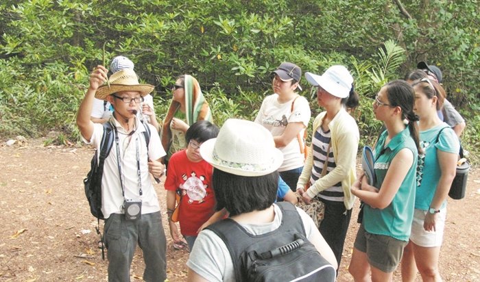 吴咏铨（左）透过Fun转毛甲，向参与生态导览的民众讲解山林内的植物和生物。