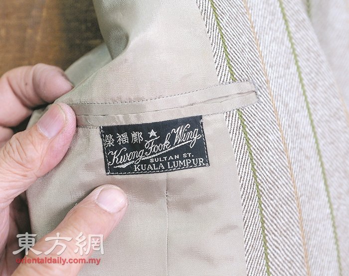 邝福荣洋服店的每件洋服，都会缝上特制标签，而此设计也是祖父自百年前传承至今。