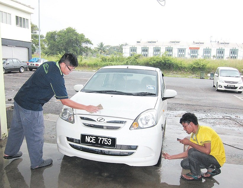 邢敬刚（左）凡事亲力亲为，也亲自为顾客洗车，提供最佳服务给顾客。