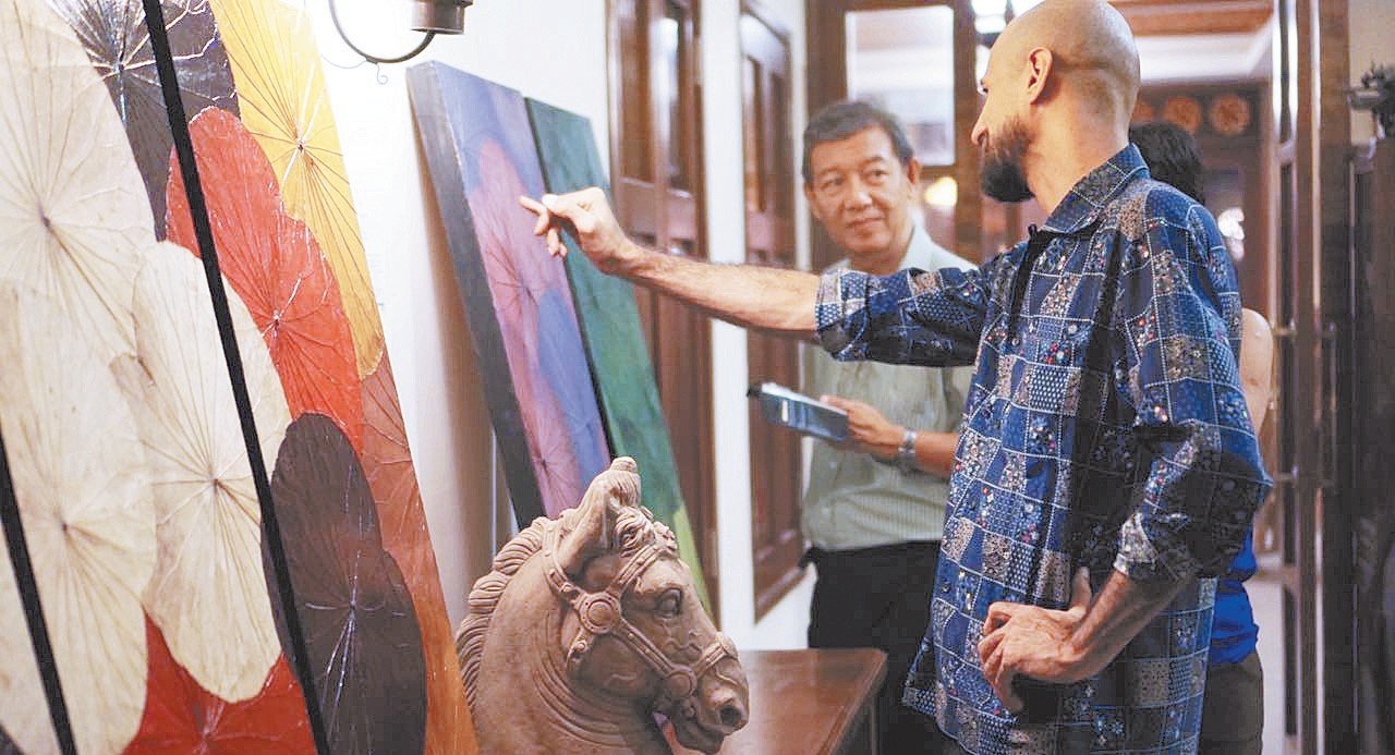 上个月，人思文与Himapan Malaysia联手在拥有百年历史的Anggun精品酒店举办了一场画展，酒店、人思文和艺术家都能从卖出的作品中获利，符合社会企业的经营模式。图为伊朗艺术家哥米尔扎林（KomeliZarin）在为看展者解说。