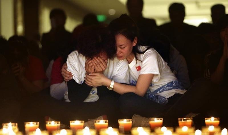 MH370乘客家属在悼念会上互相安慰。（档案照）