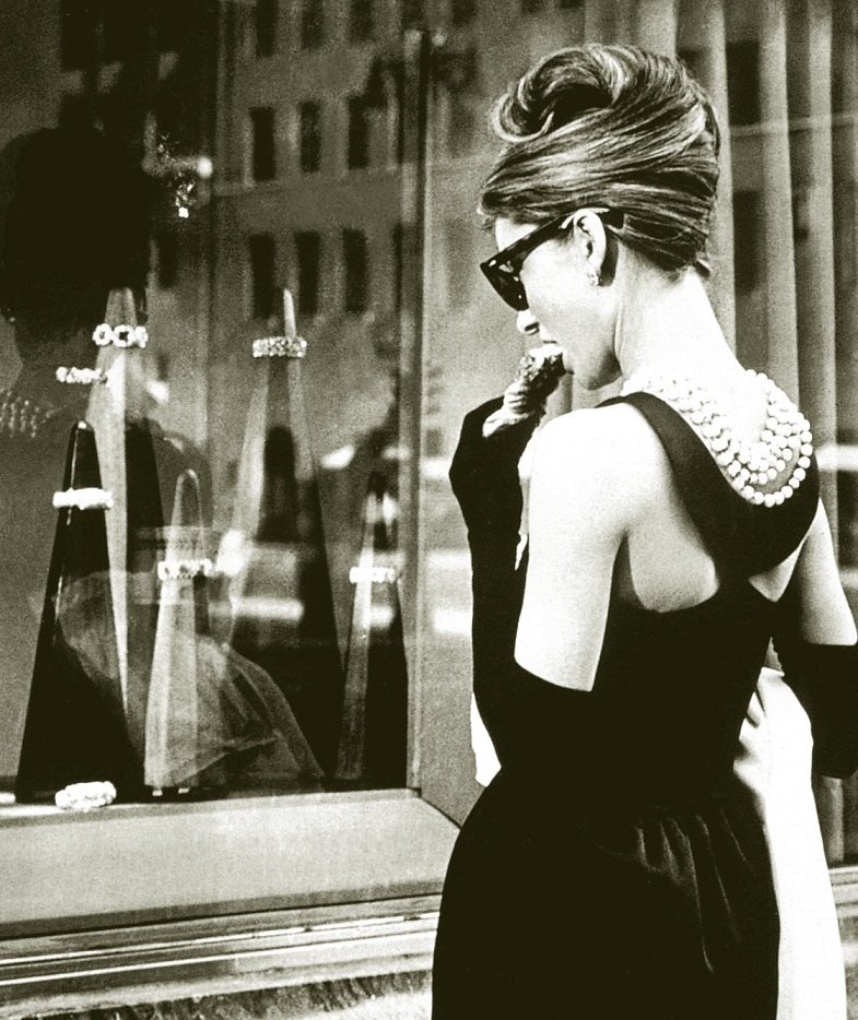 柯德莉夏萍在电影《第凡内早餐》里身穿黑色约翰哈维《黑色的故事》长裙搭配黑手套，蔚为经典。