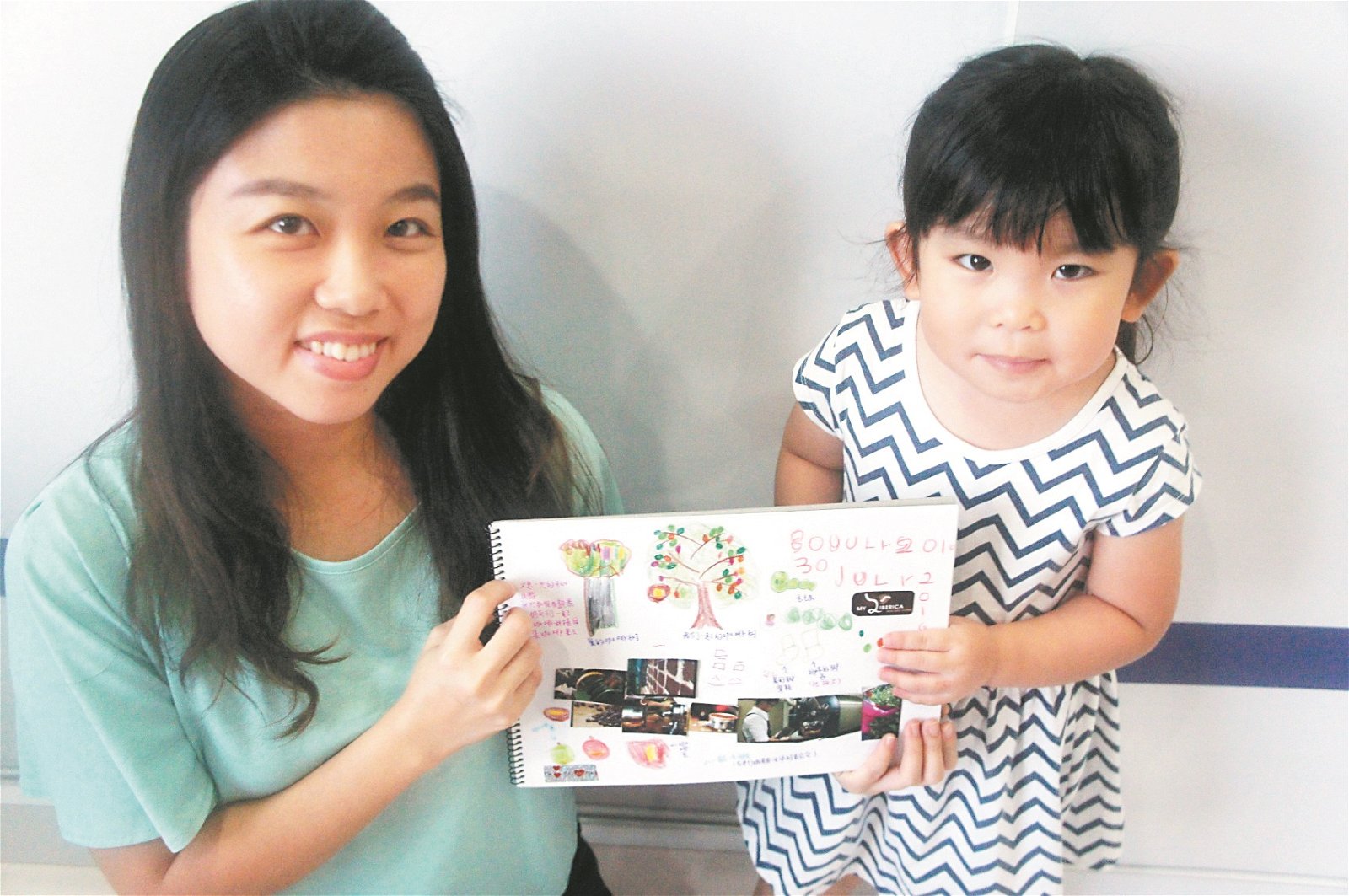 吴嫣然（左）与女儿一同展示合作完成的亲子手帐。