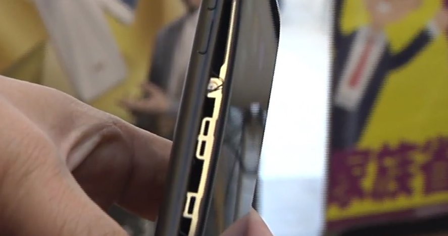 iPhone 7 Plus萤幕被撑的弯曲，机身侧面的裂缝达0.5公分。（图截自视频）
