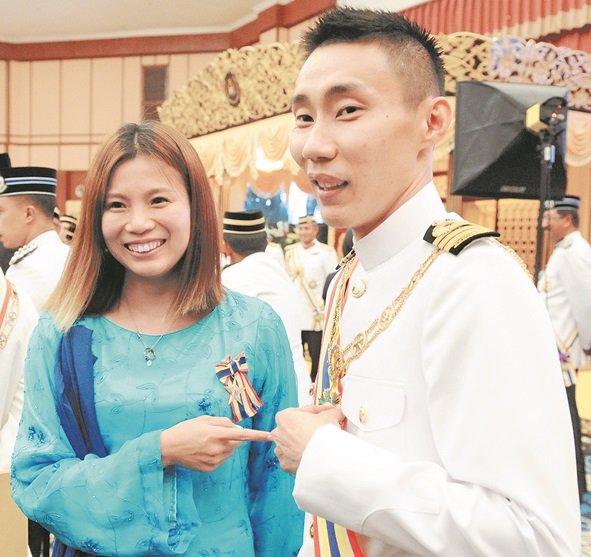 吴柳萤（左起）、李宗伟指著彼此的勋章，与大众分 享受勋喜悦。