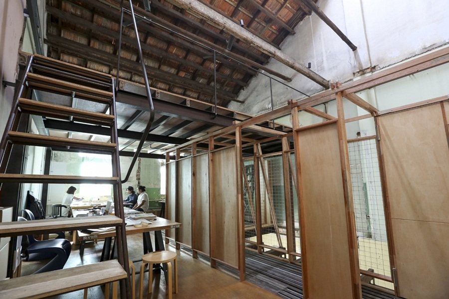 老屋二楼宽敞的空间隔间起来，是一间间的工作室；使用的不是实的墙体，仅用板块及木条围合整个空间。木条纵横交错，形成空间独特的美感。