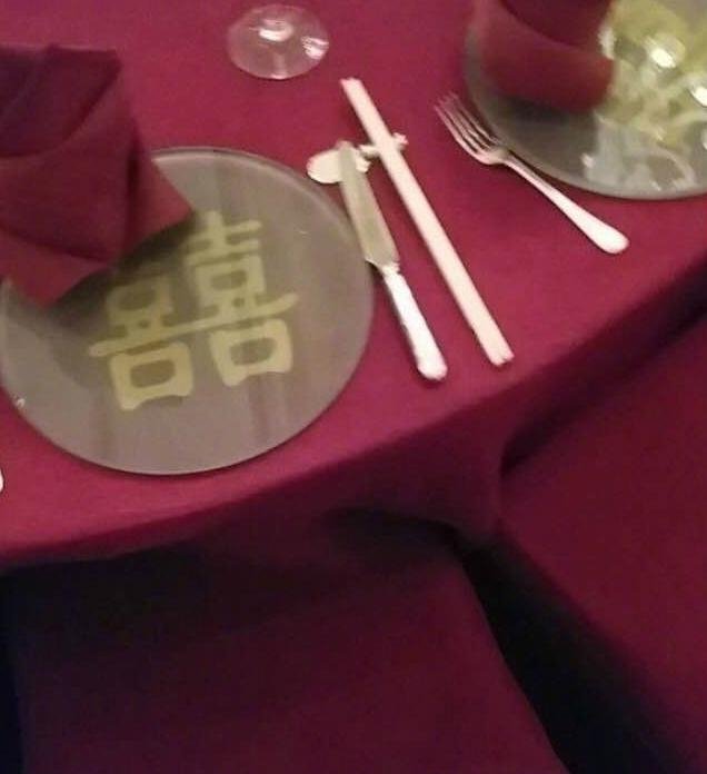 婚宴场内有千朵粉色红玫瑰，两家主桌使用枣红色桌巾和金色“囍”字餐垫。