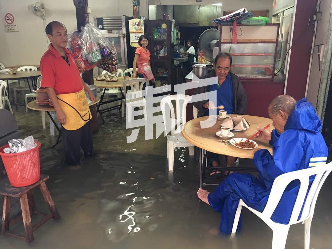 姑务路一家咖啡店变成了“水上咖啡店”，顾客在水上吃早餐。（摄影：朱智威）