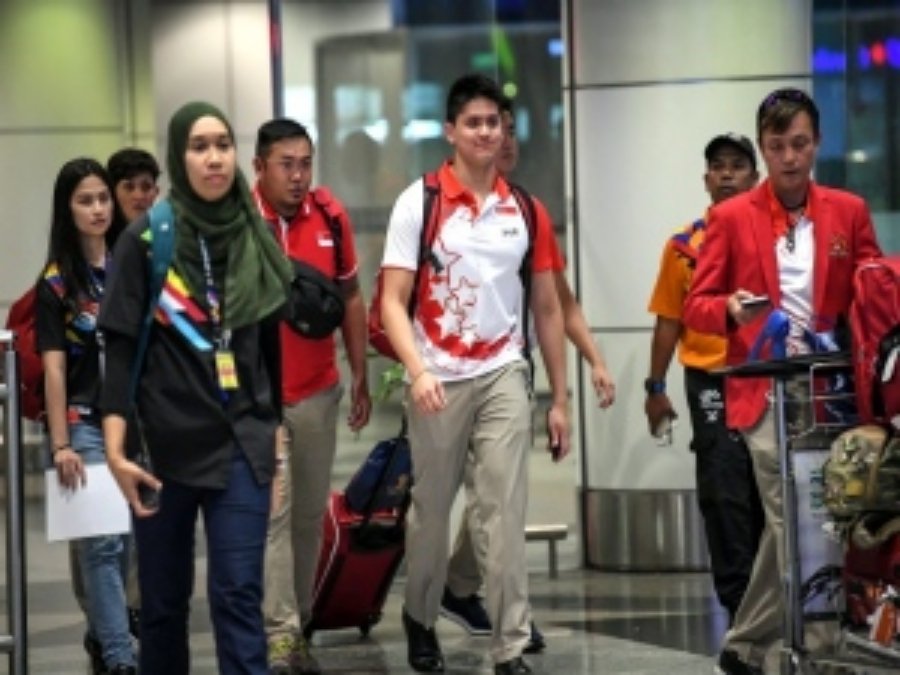 新加坡游泳奥运冠军斯库林（中）在周五晚上，抵步吉隆坡国际机场，顿时被大马媒体重重包围。