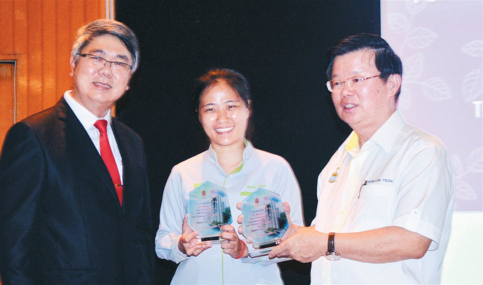 毛继荣（左）颁发纪念品给槟州绿色机构代表徐玄芬及曹观友。