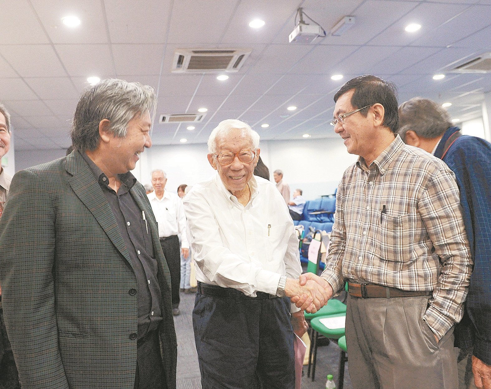 黄茂桐（中）出席双福文学出版基金40周年庆活动上，与《东方日报》总编辑潘友来（右）握手寒暄，左为戴炳基。（摄影：陈启新）