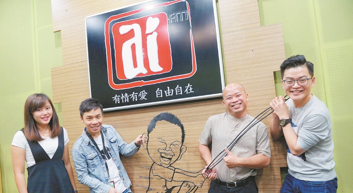 李祥（右2）偏好以铁线艺术记录上一代人的生活方式及儿时回忆，并展示出其其中一个作品，名为甘榜仔。左起：郭佩芬、谢劲程及苏进川。（摄影：陈启新）