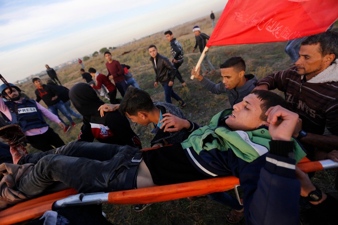 巴勒斯坦人和以军周一在加沙市东部的边境城市爆发冲突，一名和以军冲突后受伤的男子被民众抬离现场。