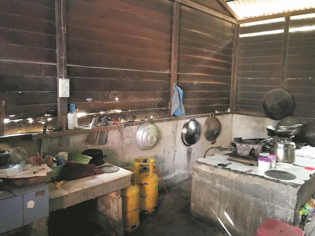 厨房的木板经历风吹雨打的摧残，已经出现破洞，但是林原利及家人却没有经济能力维修。