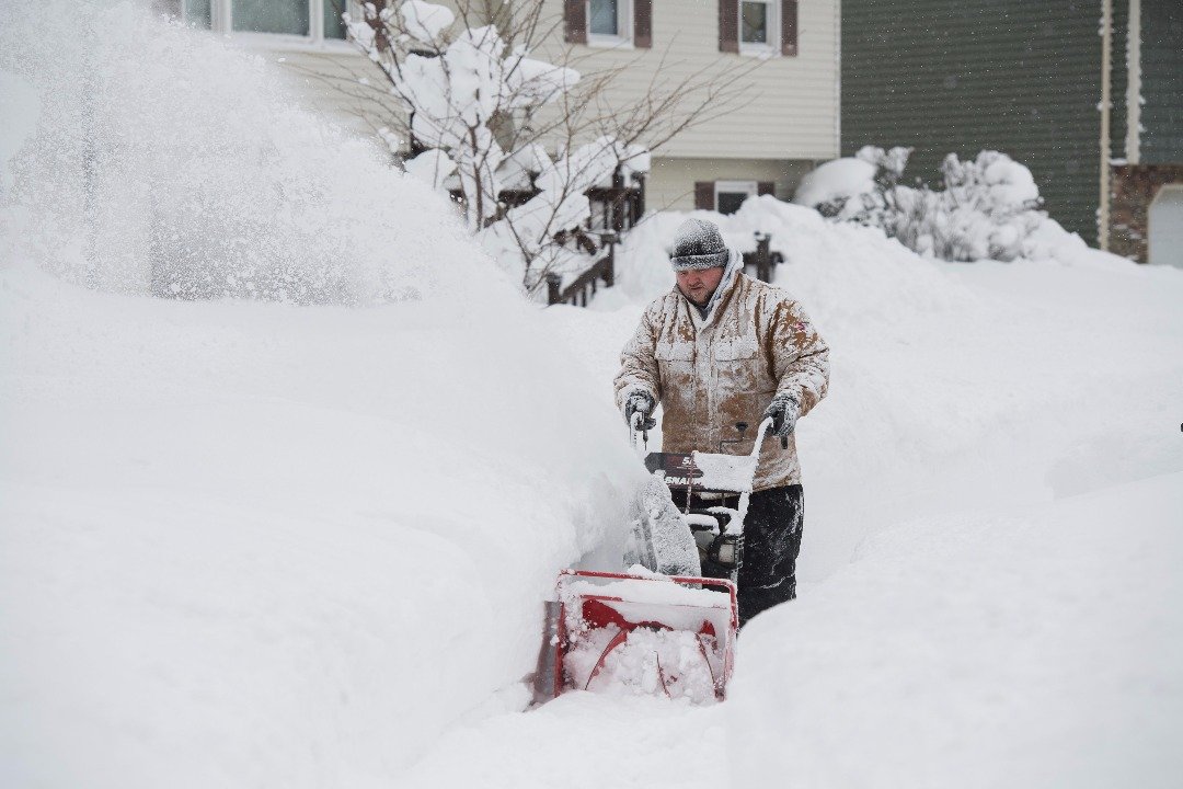 美国宾西法尼亚州的伊利市，日前录得破纪录的降雪量，街上积起了厚雪。当地民众冒著雪，推著铲雪器，清理人行道上的积雪
