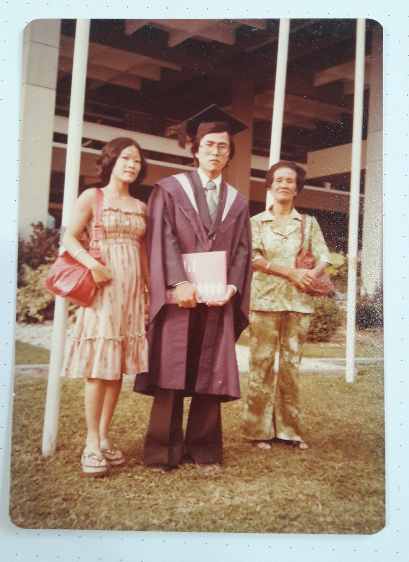 来自小地方的沈钧积是上世纪70年代有幸上大学的孩子，毕业于马来西亚理科大学。左右两旁分别是母亲和妹妹。