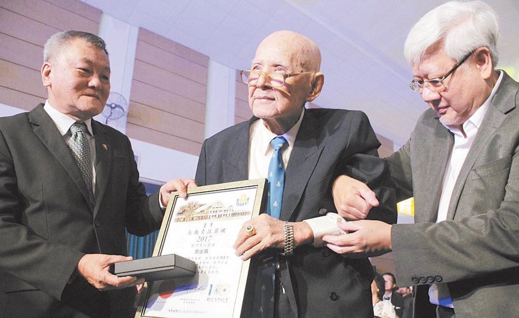 服务钟灵董事会已53年的胡由凤（左2）获颁长期贡献奖状。左为郭显荣。