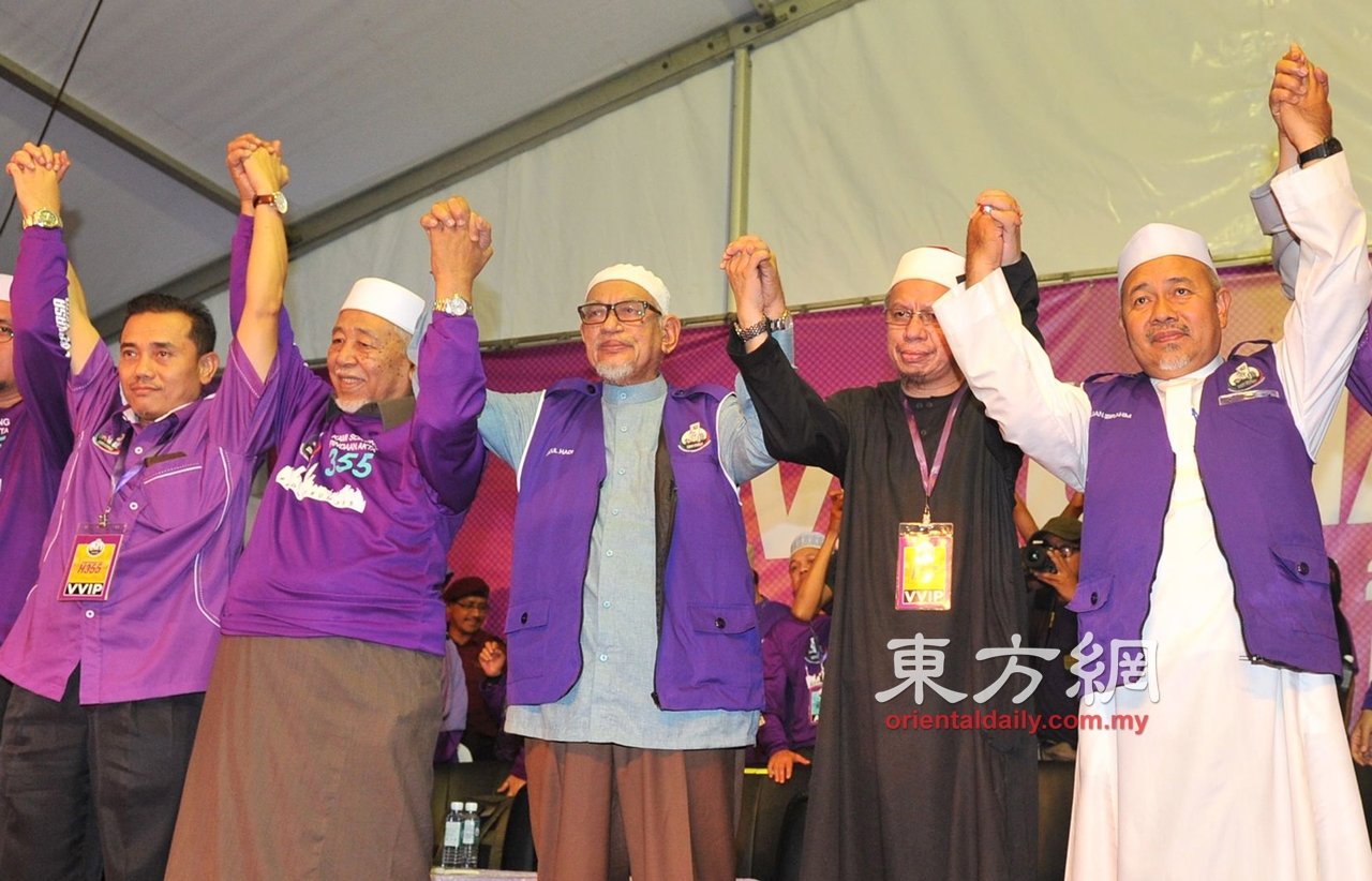 哈迪（中）周六与伊党领导层高举双手，庆祝成功于周六在吉隆坡马莫操场举行的“支持355法案集会”。（摄影：陈为康）