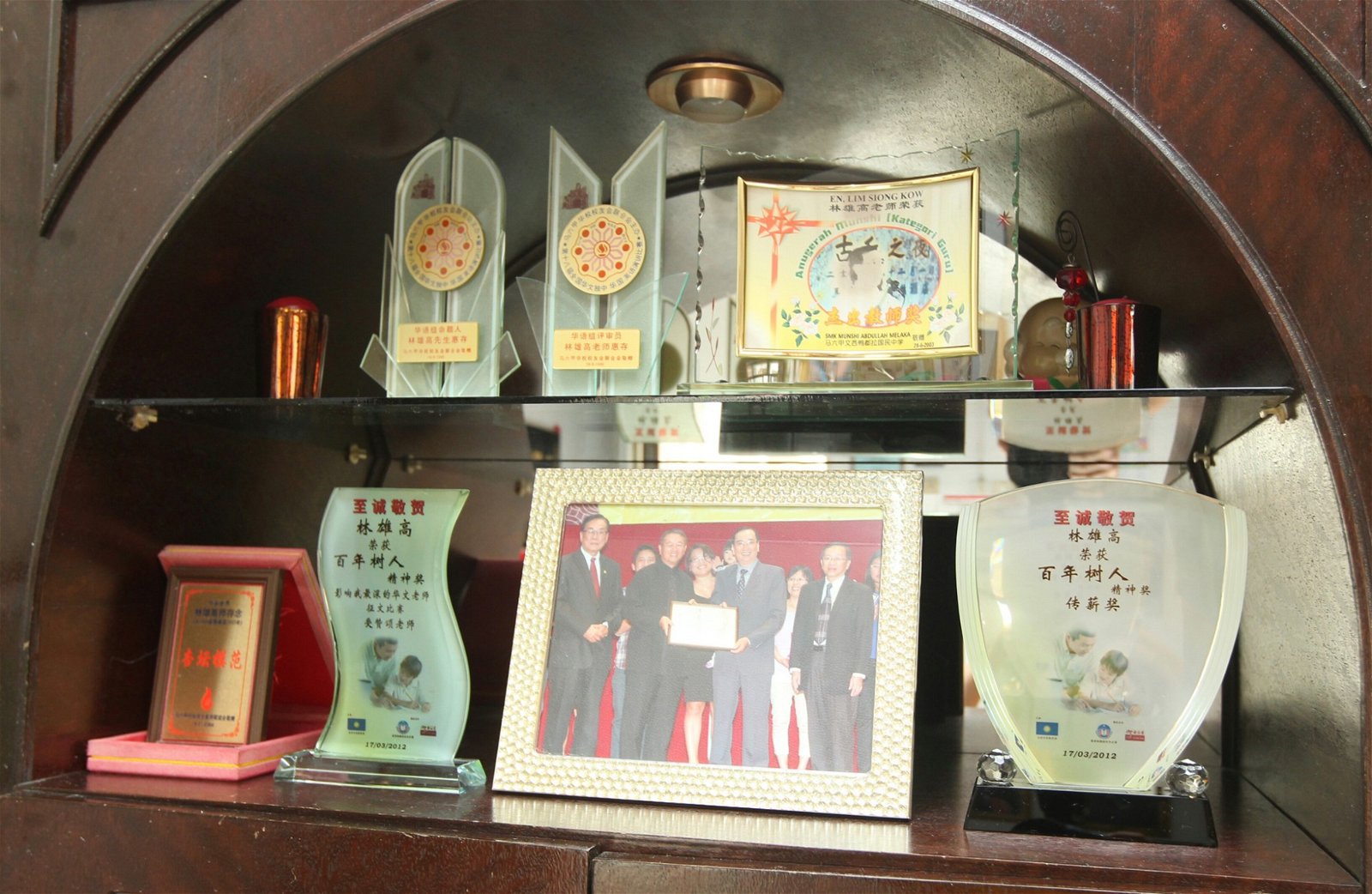 林雄高家里的墙壁和柜子里满是奖状、奖牌和学生赠送的感谢牌匾。（摄影：张真甄）
