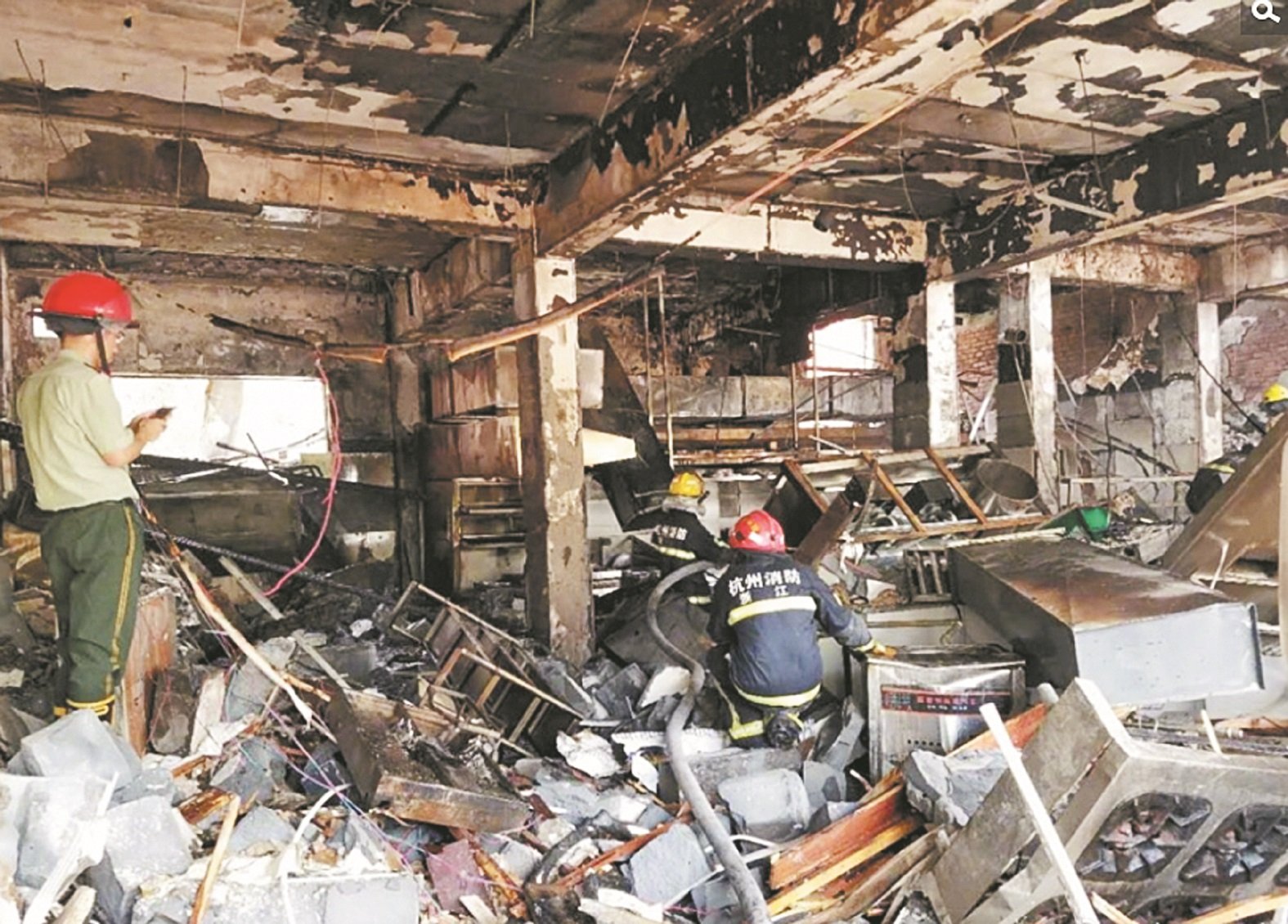 爆炸威力强大，事后现场餐馆里一片狼藉，如同遭受战火的废墟。消防人员在被炸毁的餐馆内搜证。