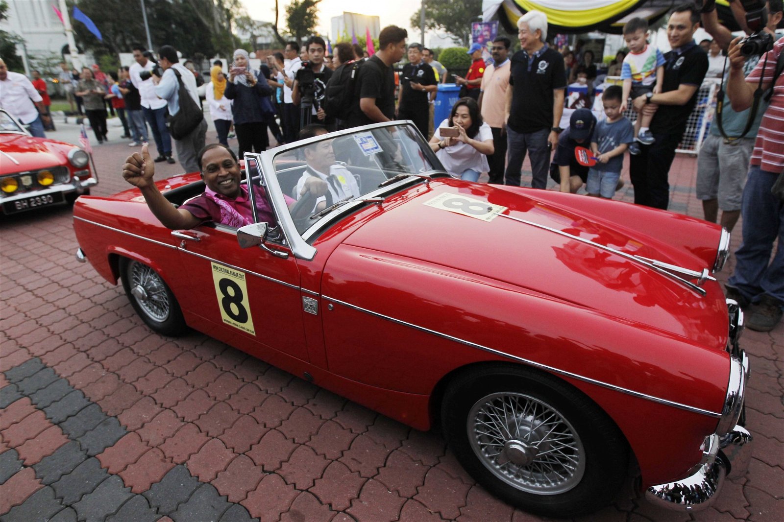 赞比里（左）亲自驾驶古董车进入会场，吸引大批民众围观拍照。