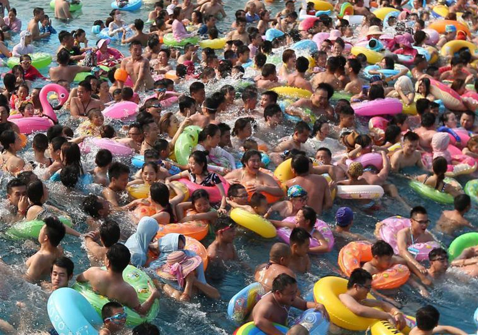 周日大批市民涌进南京欢乐水魔方内戏水、冲浪觅清凉，现场到处挤满人群。当地气象台将高温橙色预警升级至红色预警。