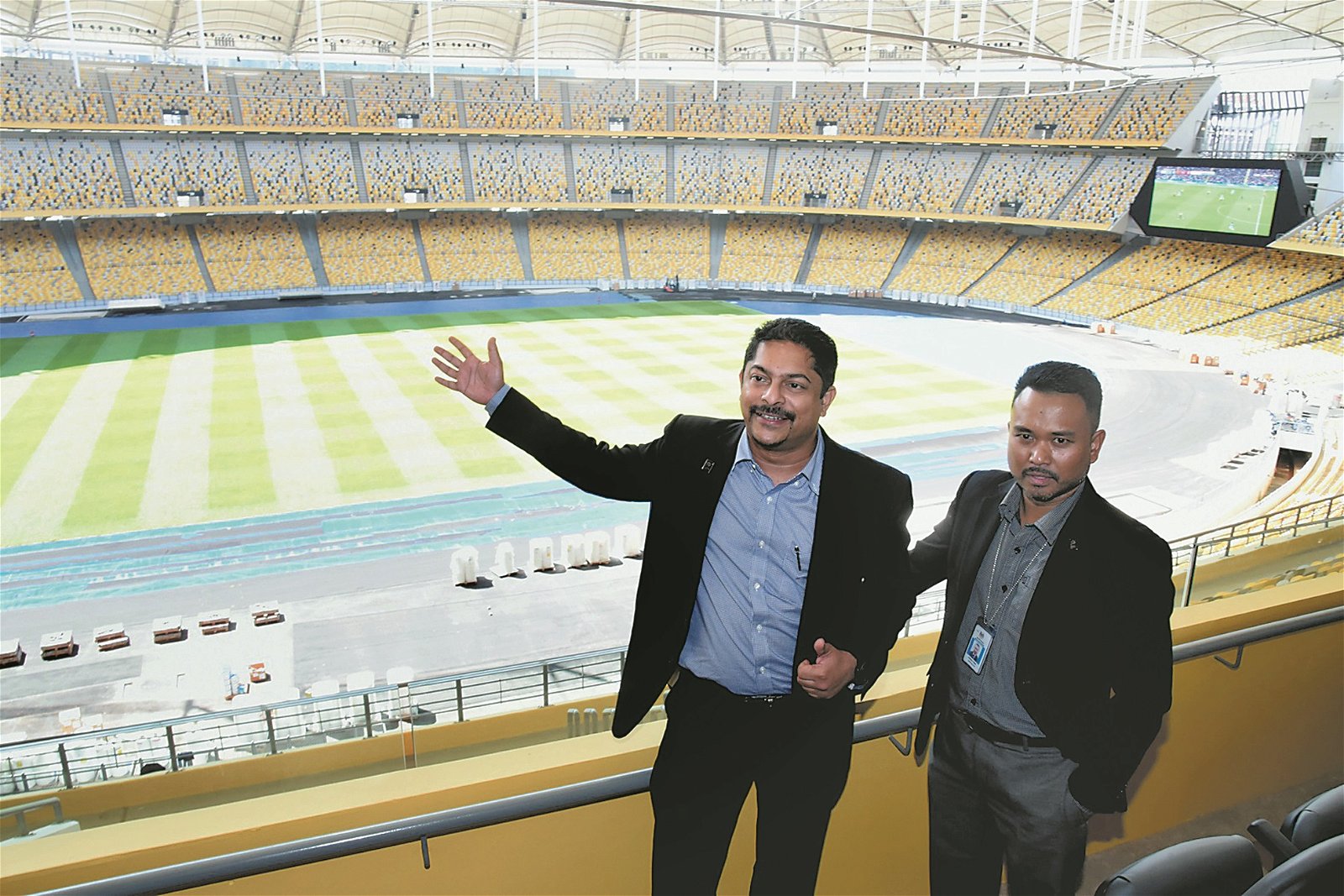 纳古拿林甘（左）与阿兹曼带领媒体参观换上新装的国家体育场。其中，观众席装上黄黑色椅子，以营造出“马来虎”特色，成为大马国足的主场。