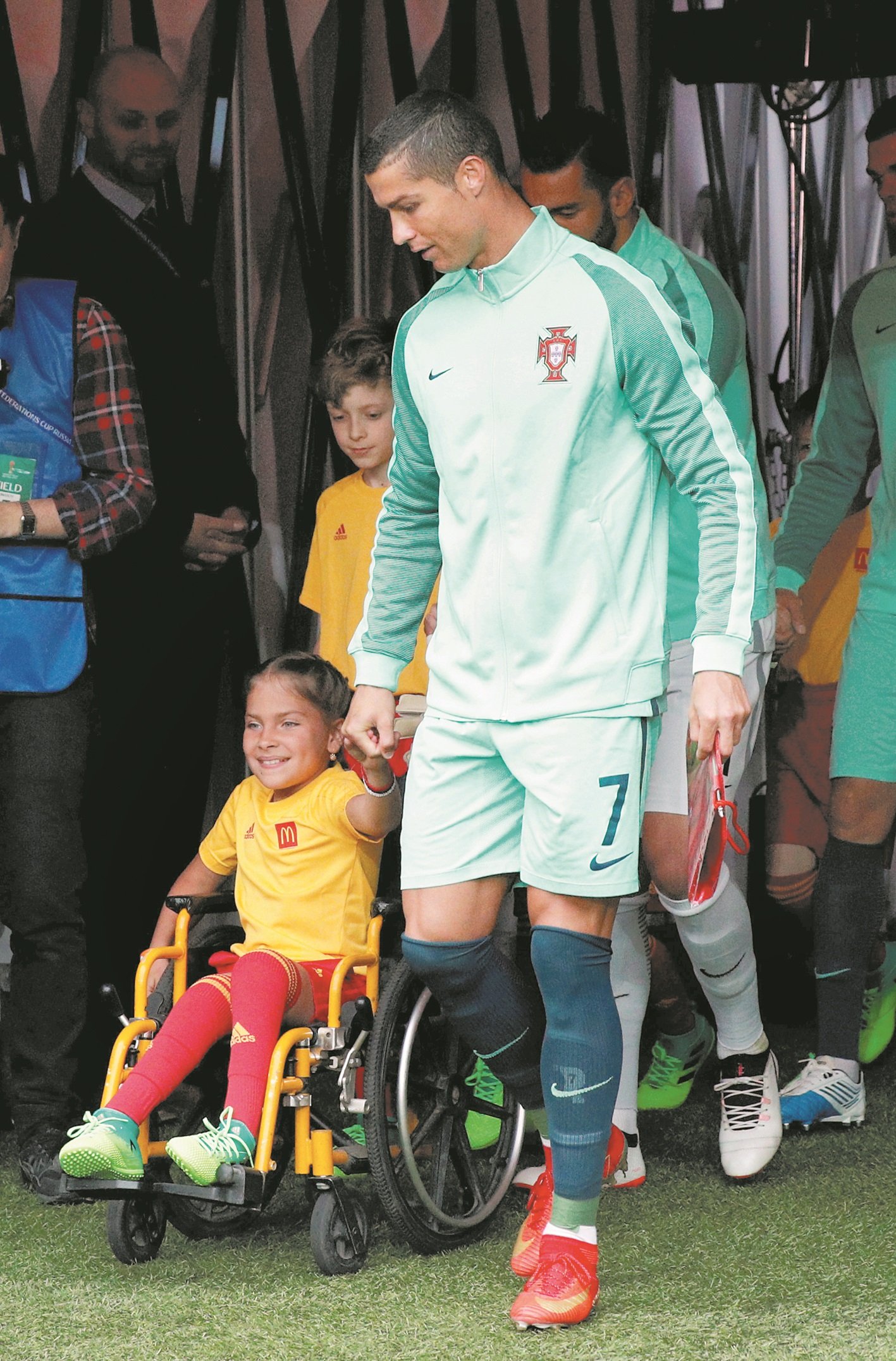 葡萄牙队长C.罗纳多（右）在入场仪式中，牵著一名坐轮椅的10岁女孩波莉娜进场，并在后者额头上亲吻的暖心动作，让不少球迷印象深刻。