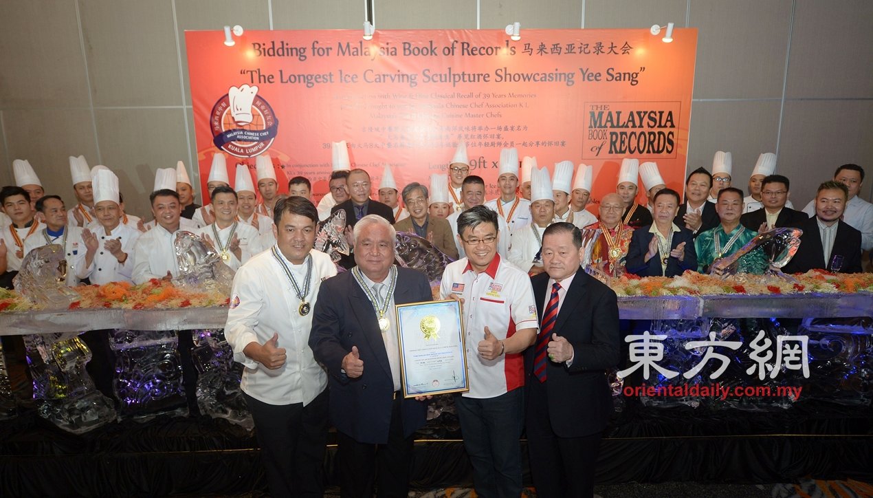 叶育华（左2起）从黄枫伟手中接过“大马最长水晶冰雕鱼生”的马来西亚纪录大全。左为李金潠及右为刘为强。 （摄影：陈启新）