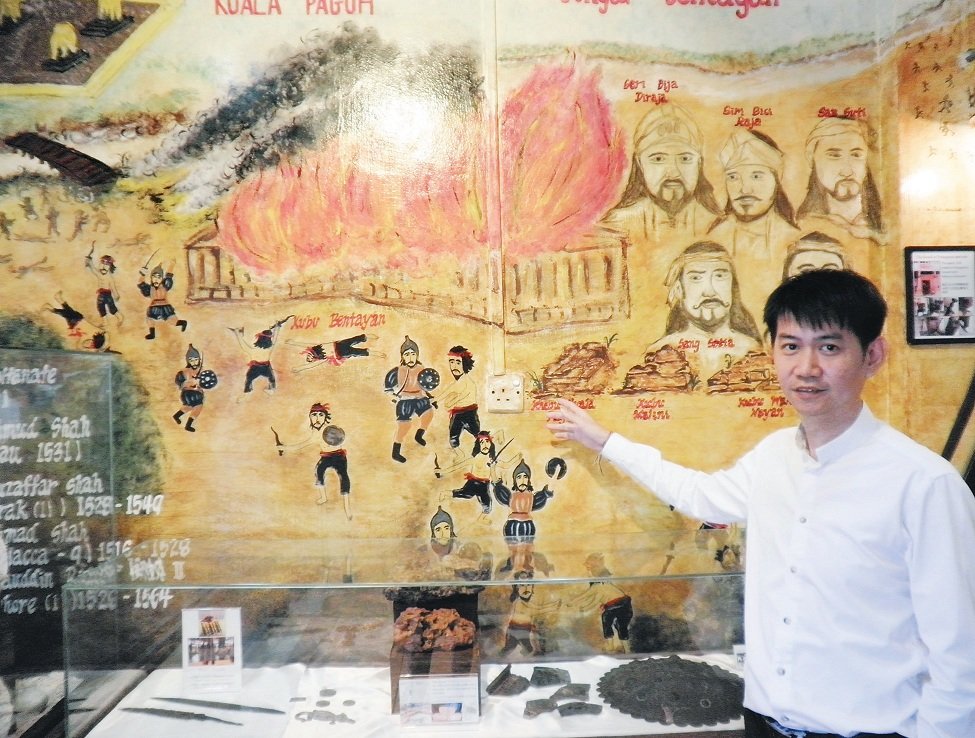 张炳兴通过历史餐厅内的壁画，向各界民众叙述麻坡的历史。