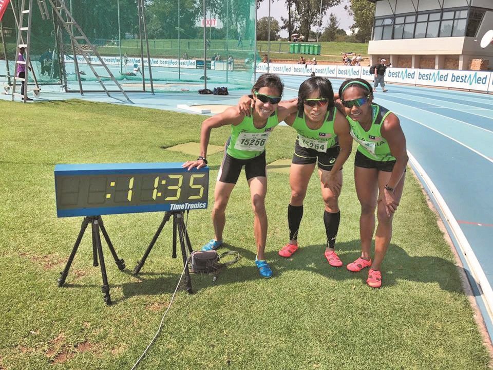 大马女子100公尺军团在新全国纪录成绩电子告示牌旁留念，左起为再达杜、法蒂玛和科玛兰。