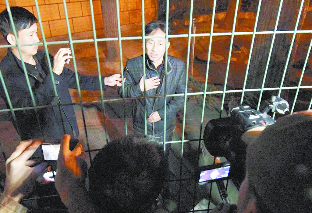 李忠哲周六凌晨在北京的朝鲜驻华大使馆，隔著铁栏向大批记者讲话，声称自己被冤枉。