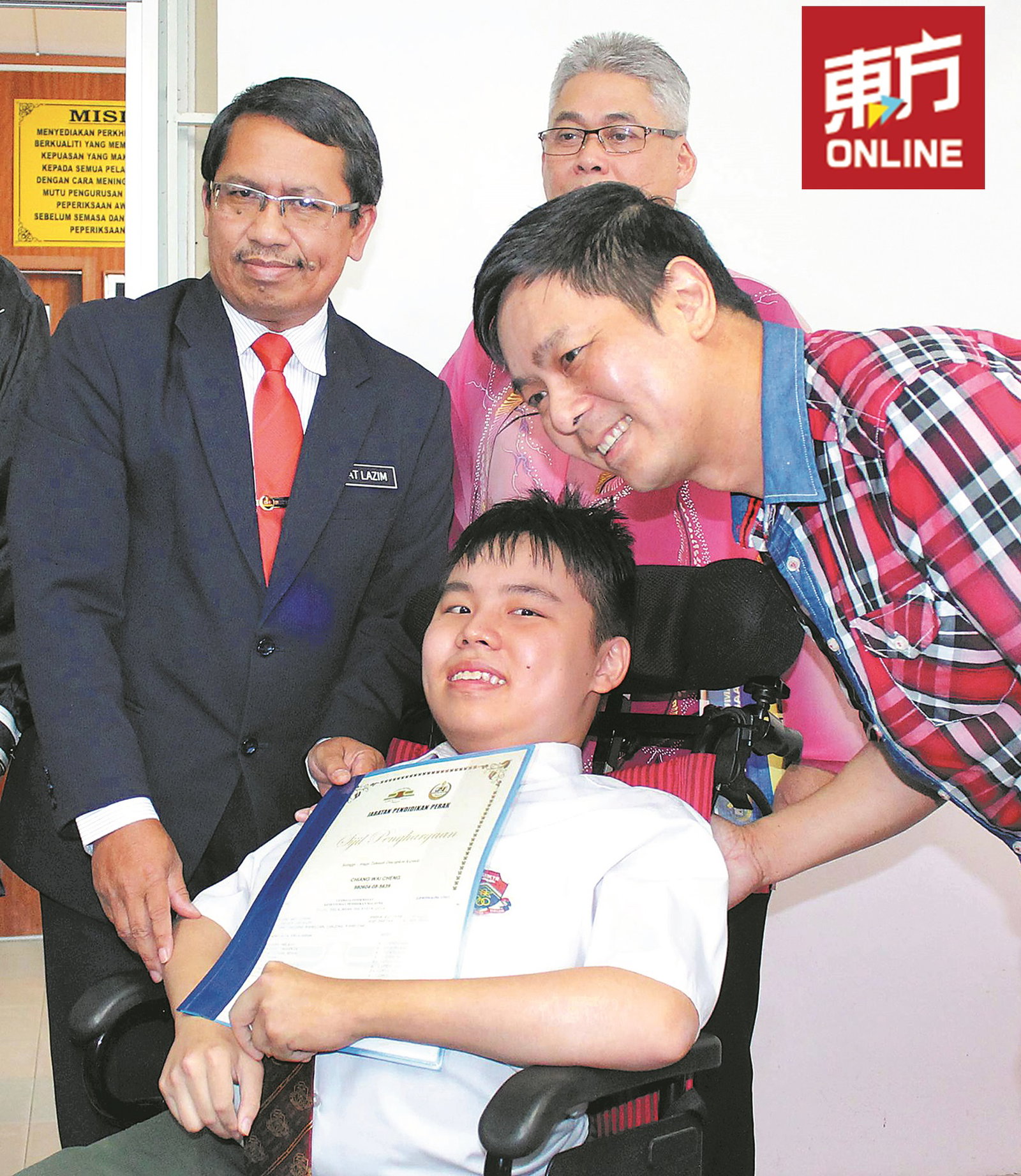 为霹雳州教育局局长末拉金（左）颁发奖状给 郑伟城后，与这对坚强的父子合影。