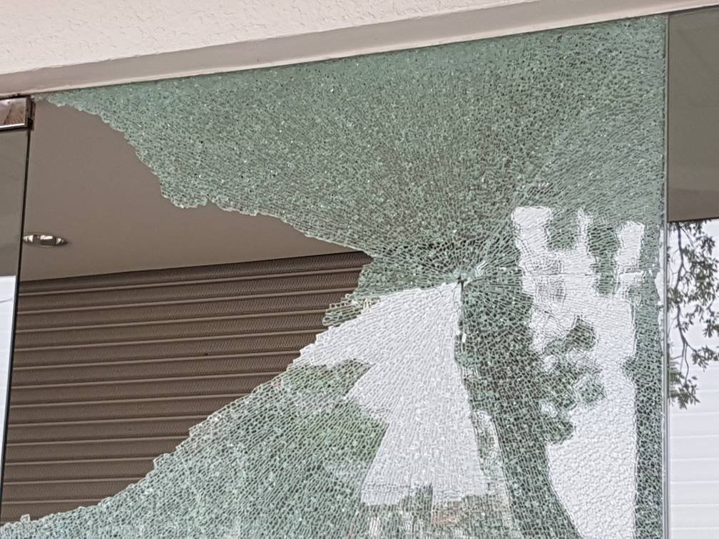 联昌国际银行大门旁的玻璃镜留下一个类似遭子弹击穿的小孔。（摄影：邓翠玲)