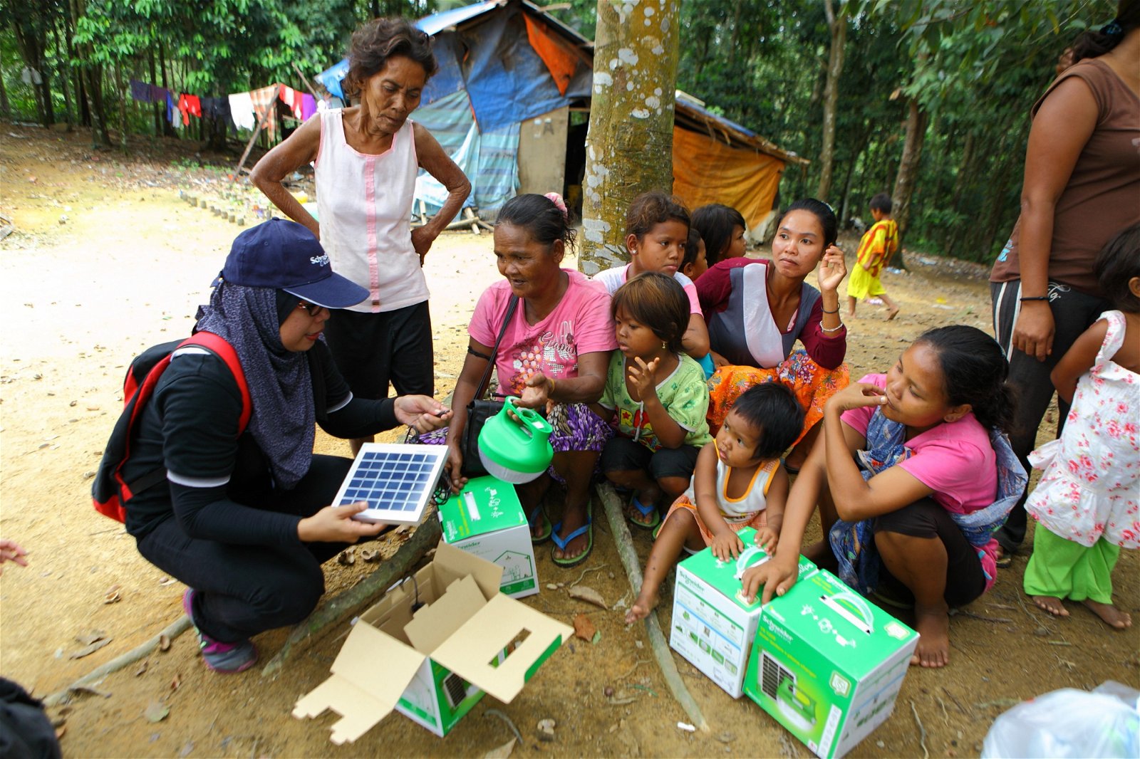 义工为村民讲解Mobiya便携式太阳能灯的操作方式。