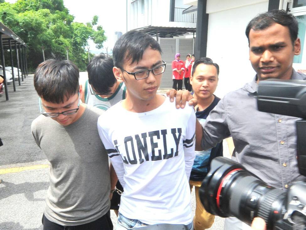 李宗圣（左穿灰衣者）与另2名华裔青年遭延长扣留3天助查。（摄影：邱继贤）