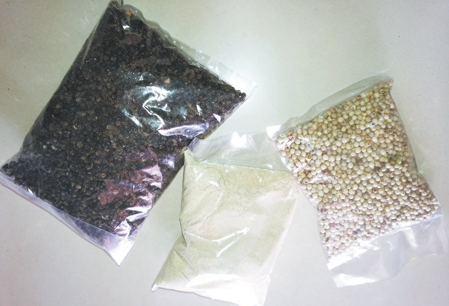 傅银水自制的制成品有黑胡椒粒（左起）、白胡椒粉、白胡椒粒，主要供给药材店或干货批发商。